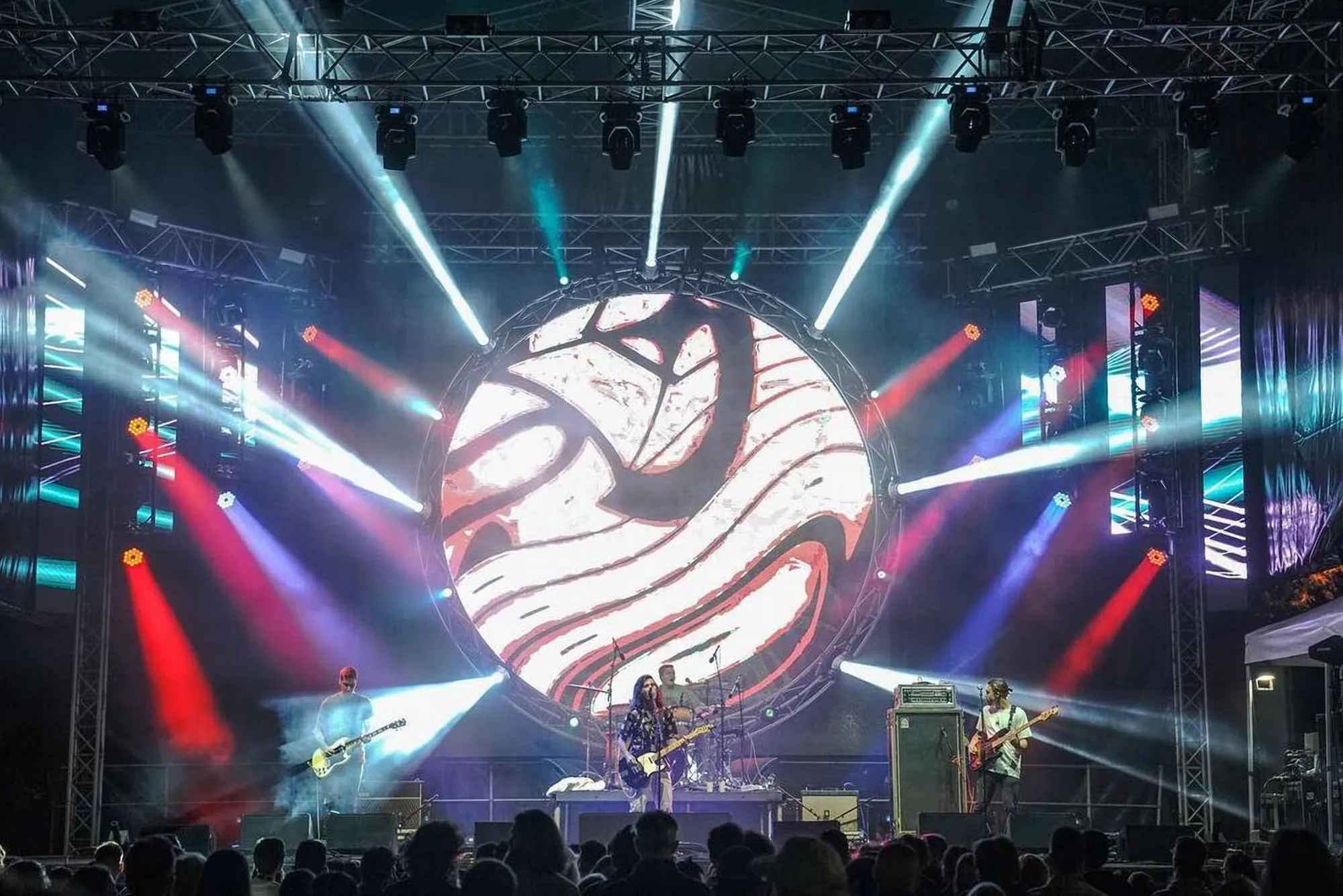 Band on stage under a round LED screen
